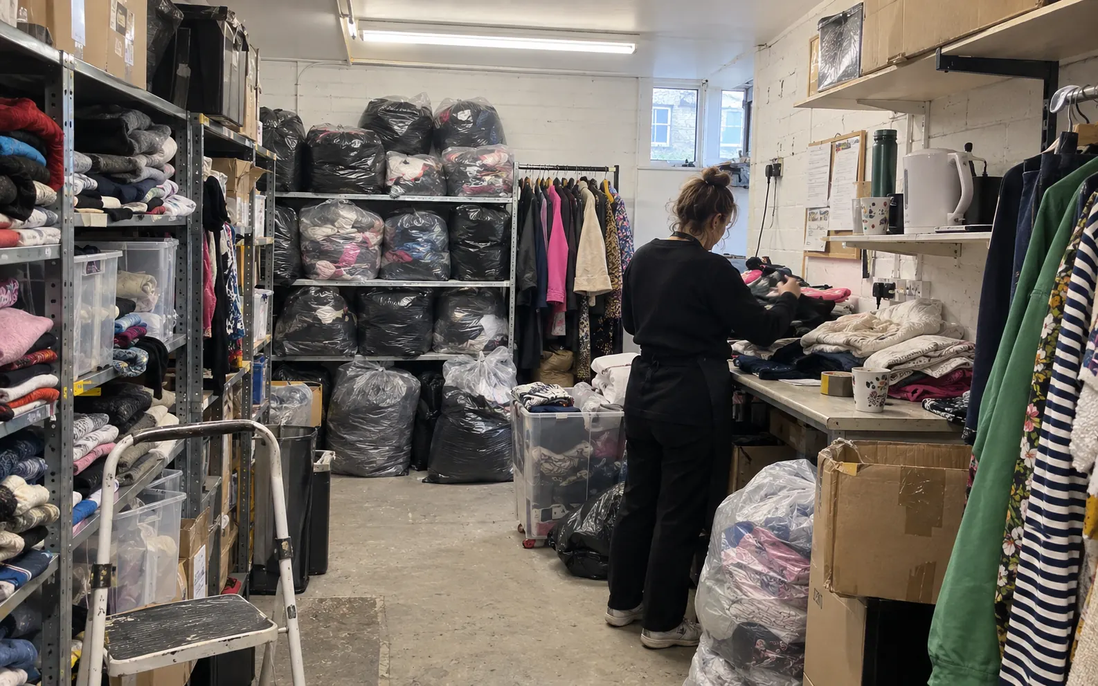 Bagged donations in a charity shop back room